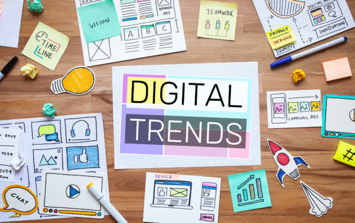 A desk with various papers and drawings related to digital marketing trends, including concepts like timeline, vision, teamwork, product and service, innovation, chat, and carousel ads, with a central focus on the words 'DIGITAL TRENDS'.